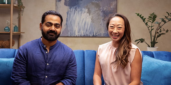 Dr Karan Rajan sitting with Han-Mi Walsh-Riddle in the studio