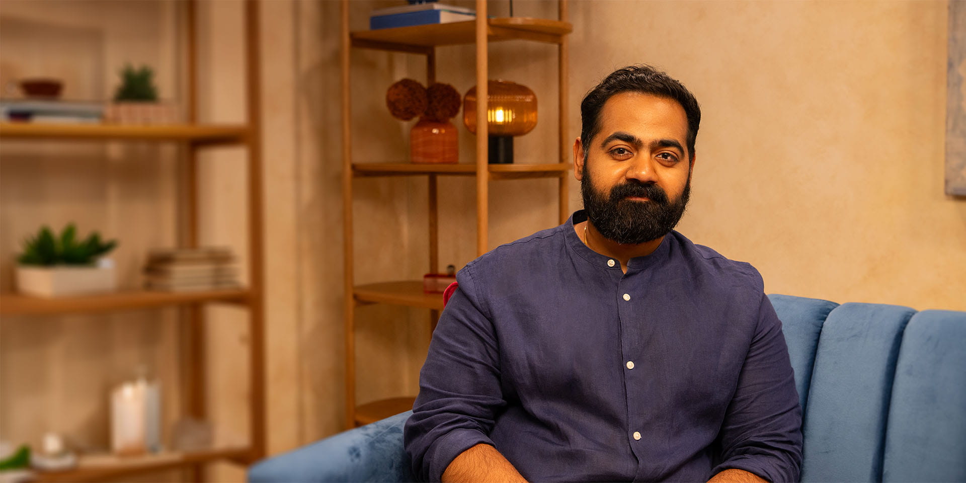 Dr Karan Rajan sitting on a blue sofa