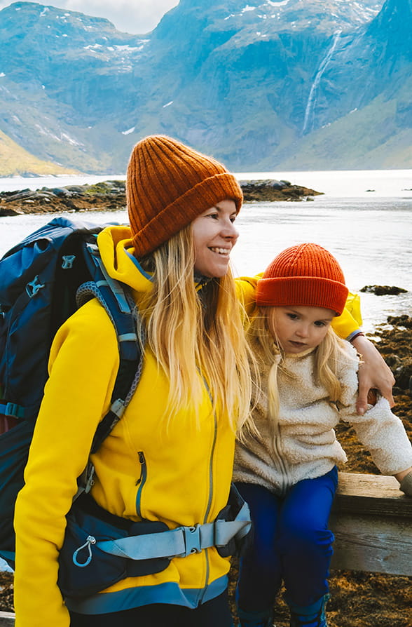 Mother and daughter hiking near a lake in the mountains