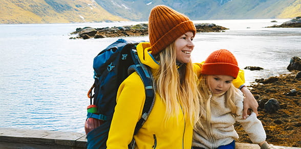 Mother and daughter hiking near a lake in the mountains