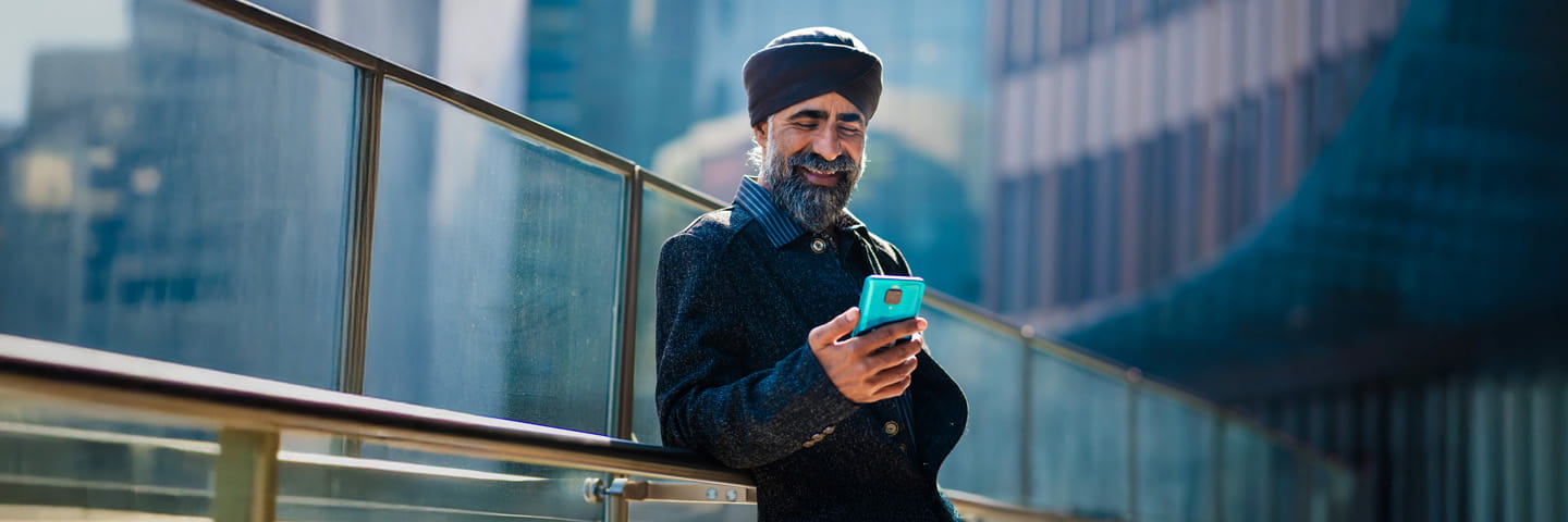 Person smiling at phone while standing outside