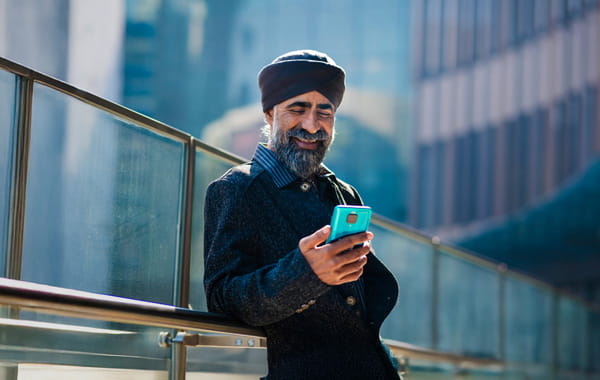 Person smiling at phone while standing outside