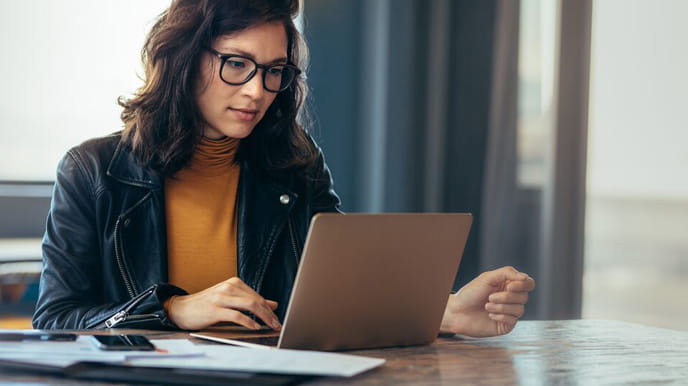 Person reviewing documents on laptop