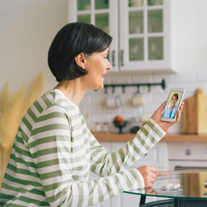 Woman sitting in a kitchen on a video call