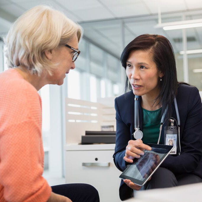 Doctor showing a radiograph to a patient on a tablet device