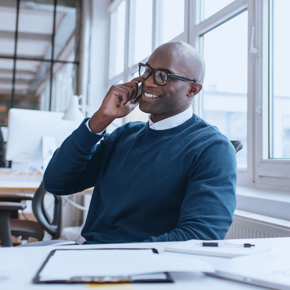 A man in an office taking a phone call