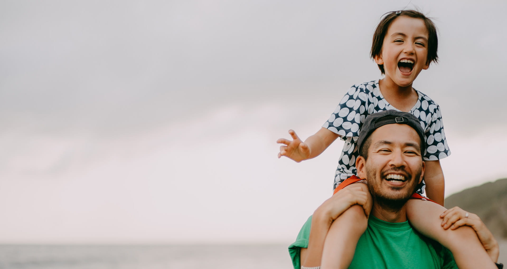 Adult at the beach with child on their shoulders