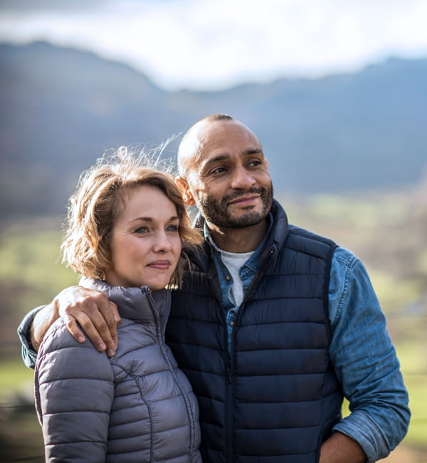 couple pausing on a mountain walk to enjoy the view