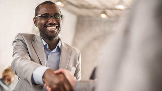 Person smiling while shaking hands