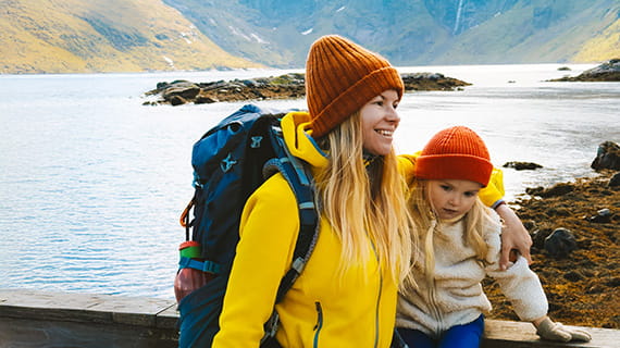 Woman and child near a lake, wearing cold weather hiking clothing