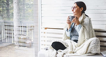 Woman drinking tea looking at window