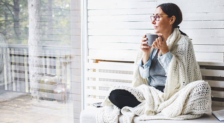Woman drinking tea looking at window