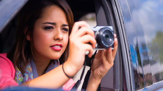 woman taking photograph from car window