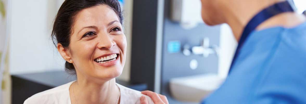 Woman smiling up at doctor in doctor's office