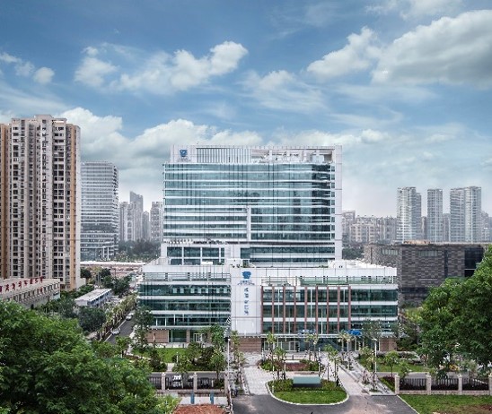 An aerial view of the Guangzhou United Family Hospital building with a park area with trees in the foreground
