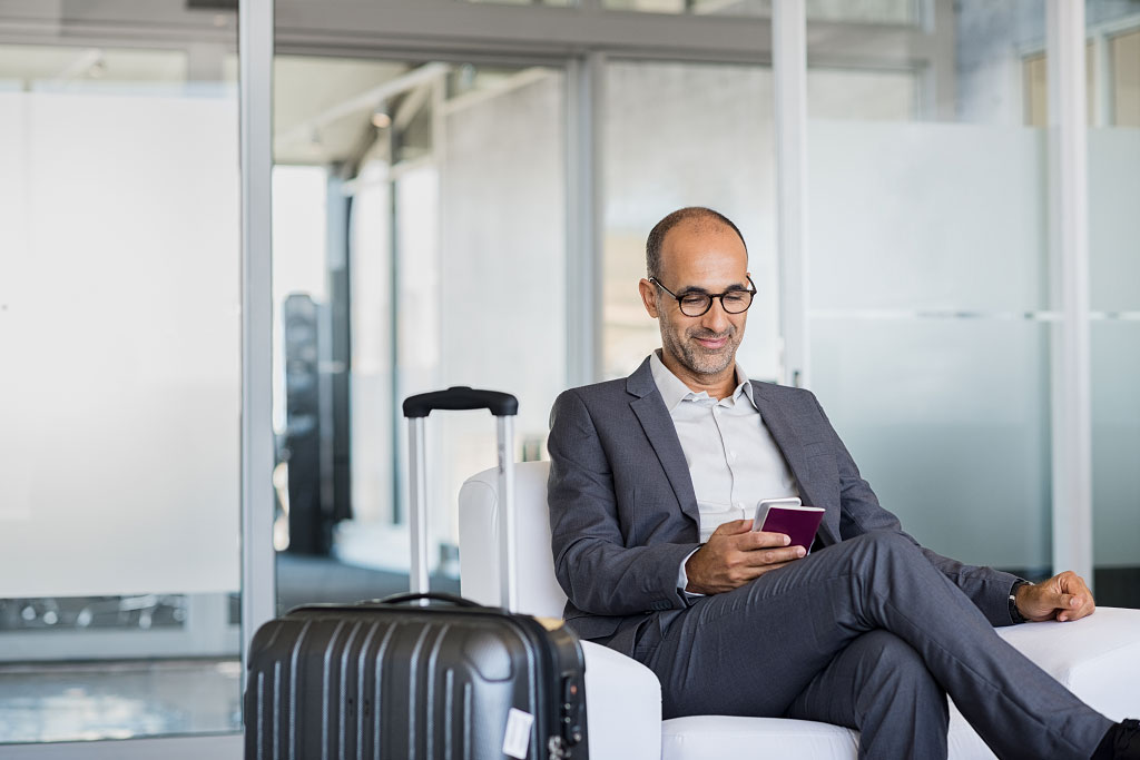 Man sitting in departure lounge - Expatriate Insurance and Corporate Travel