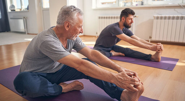 Two men stretching - Can keeping fit help extend your lifespan?