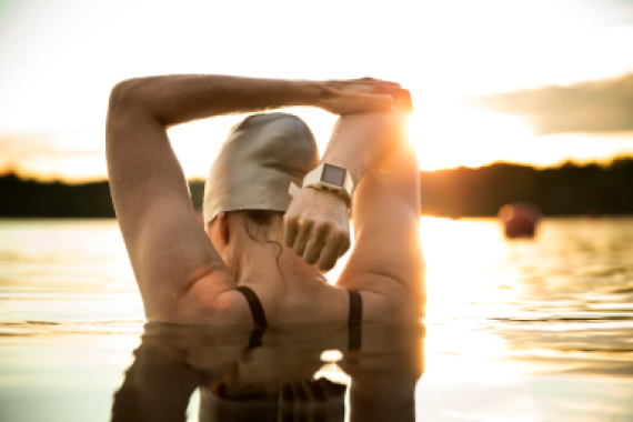 Image of a swimmer in open water stretching.