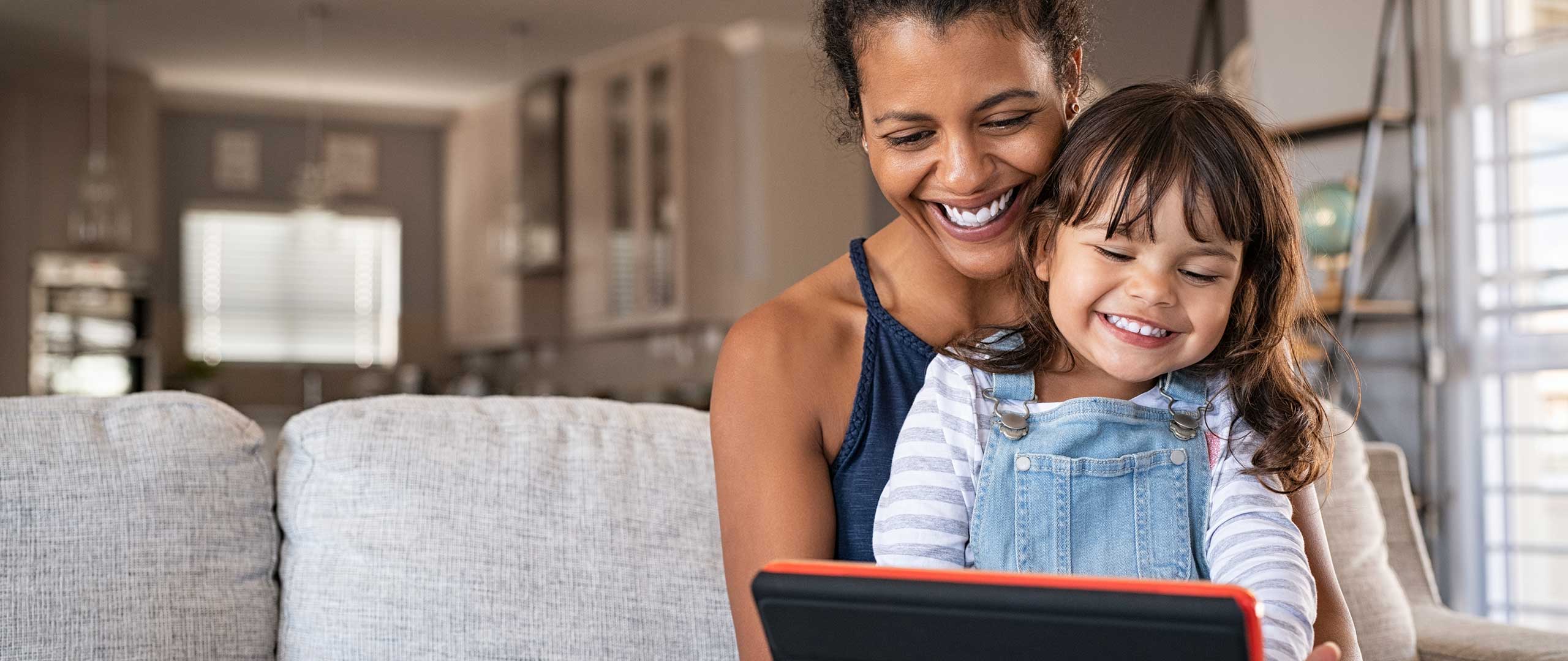Woman and child sitting with a tablet device.