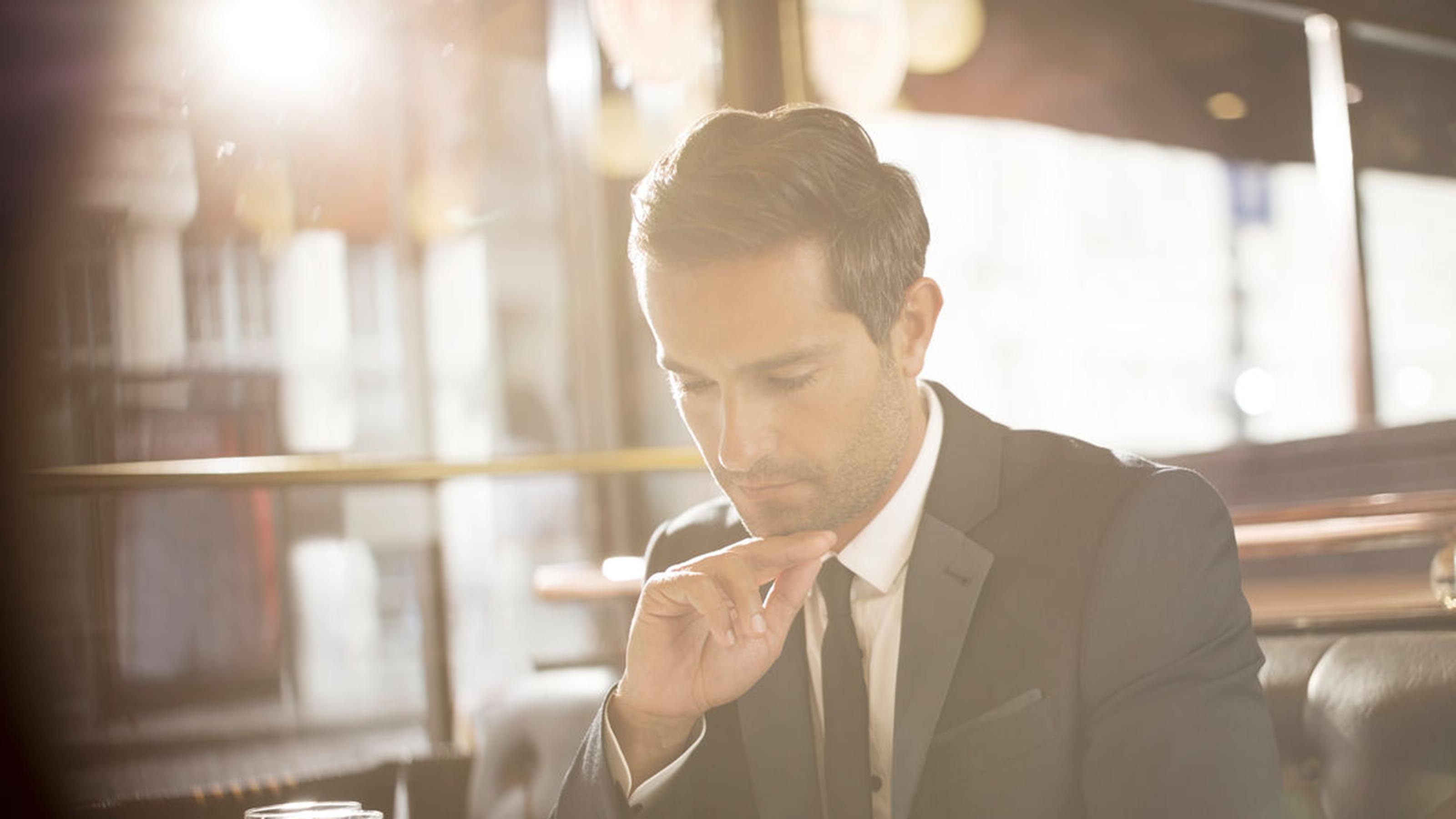 Businessman sitting in a restaurant reading 