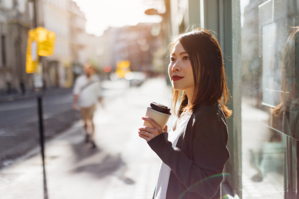 woman standing outside in street with coffee