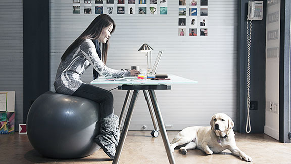 Woman sitting on a medicine ball