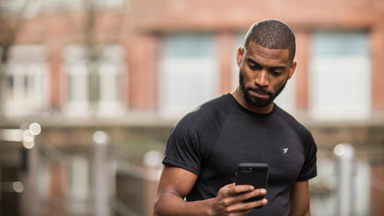Man checking smartphone in gym clothes