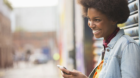 Woman smiling, holding mobile phone