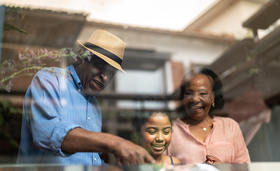 Parents looking out the window laughing with their daughter
